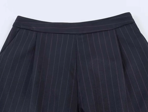 Detail view of navy blue pinstripe suit shorts with elegant pleats and smooth waistband
