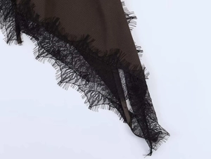 Détail du tissu marron foncé avec bordure en dentelle de cils noire sur l'ourlet