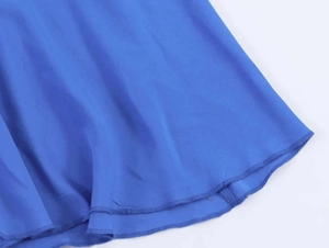 Détail d'une robe bleu roi montrant les coutures précises de l'ourlet roulé à double aiguille