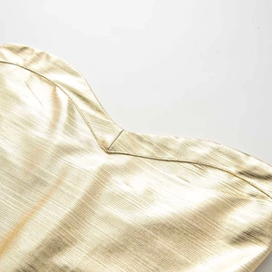 Close-up of gold bandage dress fabric showing metallic luster and fine V-neck stitching details