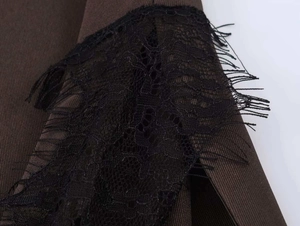 Détail du tissu marron avec dentelle noire et bords effilochés sur un haut sans manches
