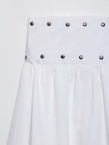 Close-up of white midi skirt featuring double-breasted buttons and pleated waist detail
