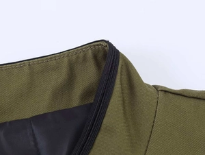 Close-up of olive green blazer neckline with black knit trim and quilted lining