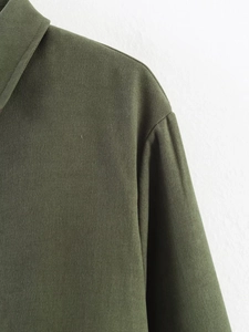Detailed close-up of dark olive flight jacket fabric texture and professional stitching