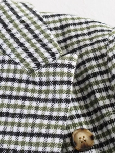 Close-up of green houndstooth blazer lapel with a premium marble texture button