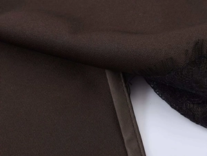 Détail du tissu sergé marron foncé avec bordure en dentelle noire et ruban de satin
