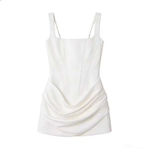 Détails de la robe moulante blanche avec coutures corset et textures de jupe froncées