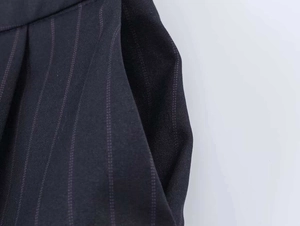 Detailed close-up of side pocket and purple pinstripe fabric texture on navy trousers