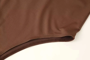 Detail eines kaffeebraunen Strick-Bodysuits mit hochwertigen Doppelnadel-Nähten und Stoff