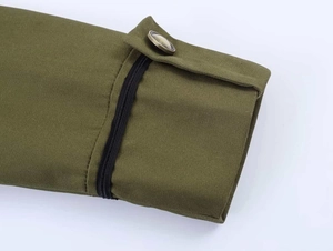 Detail of olive green blazer cuff with vintage metal button and black elastic band