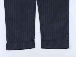 Detailed close-up of cuffed pinstripe trouser hems in a dark navy business suit fabric
