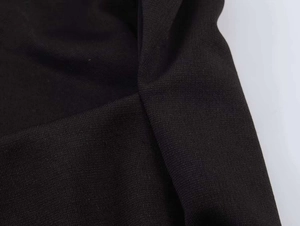 Detailed macro view of black knitted fabric showing fine stitching and ribbed hem texture