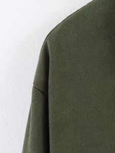 Detail of army green drop shoulder jacket showing soft brushed fabric texture