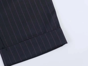 Detail shot of pinstripe suit fabric showing high-quality stitching on the cuffs