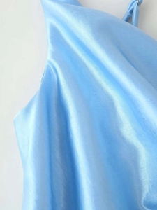 Détail d'une robe en satin bleu clair avec bretelle réglable et texture lisse brillante