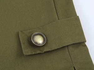 Macro detail of military green blazer featuring vintage metal buttons and twill texture