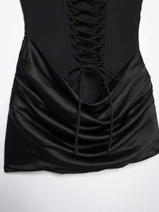 Détail du laçage croisé sur tissu mat avec des plis drapés en satin élégants