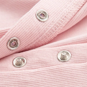 Detail der babyrosa gerippten Baumwolle Jumpsuit mit sicheren silbernen Druckknöpfen