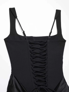 Détail du dos d'une robe corset noire avec lacets ajustables et finitions en satin chic