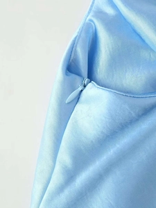 Détail de la fermeture éclair invisible sur une robe de soirée en satin bleu clair
