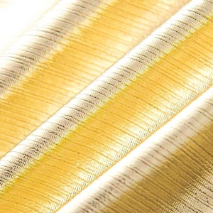 Detailed macro view of the gold metallic textured fabric with horizontal pleats