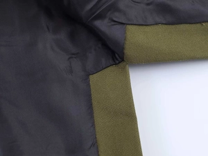 Detailed macro view of military green twill fabric seams with smooth black lining on jacket
