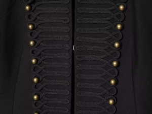 Détail d'un blazer noir style militaire avec cordons décoratifs et boutons en bronze