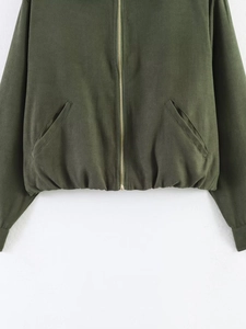 Detail of olive green bomber jacket featuring gold zipper and elastic pleated hemline