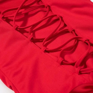 Gros plan détaillé sur le laçage croisé d'une robe rouge avec œillets métalliques