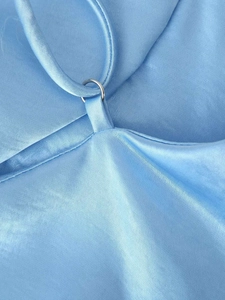 Détail de robe en satin bleu clair avec bretelle fine et anneau de connexion en métal