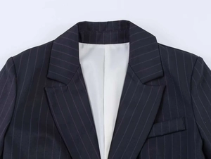 Detail of pinstripe blazer with notch lapels and clean white interior lining