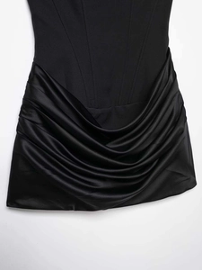 Détail de la taille corset à baleines et satin plissé sur robe courte noire