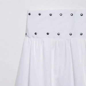 White high-waisted midi skirt with silver rivet accents and pleated balloon hem silhouette
