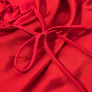 Gros plan de la robe rouge à col carré avec un nœud décoratif élégant et soigné