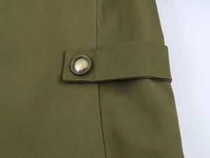 Detail view of army green blazer fabric with vintage metal button and adjustable strap