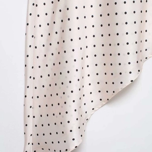 Gonna in raso a pois rosa tenue con orlo asimmetrico e consistenza setosa lucida
