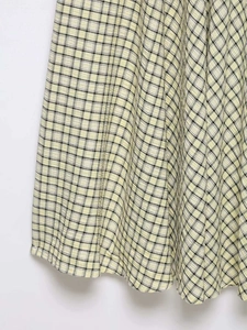 Detailed macro view of yellow and black checkered seersucker fabric texture on a midi dress