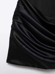 Gros plan du tissu en satin noir avec fronces latérales délicates et aspect soyeux