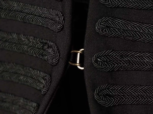 Détail de la veste hussard noire avec broderie soutache et crochet métallique vintage