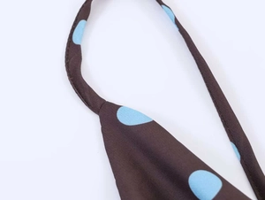 Detailed macro shot of blue polka dot print on brown fabric with high quality stitching