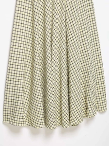 Detailed view of woven fabric texture and plaid pattern on this yellow midi skirt
