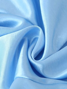 Détail du tissu en satin bleu clair montrant un lustre soyeux et une texture lisse