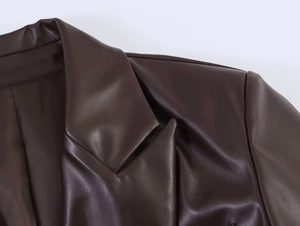 Detail of deep brown PU leather blazer showing lapel collar and shoulder seam textures