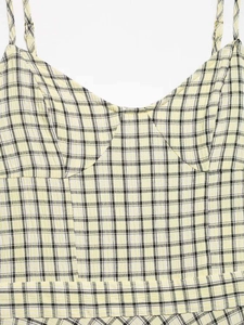 Detail shot of pale yellow plaid midi dress with thin straps and woven texture fabric