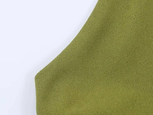Macro view showing the textured grass green pleated fabric and fine stitching detail