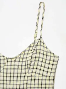 Detail of yellow and black gingham seersucker fabric with thin straps and stitching