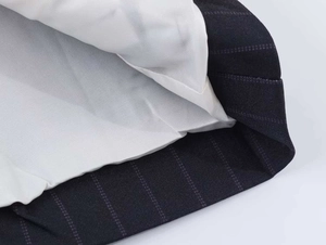 Close-up of the pinstripe suit cuff with precise stitching and white inner lining