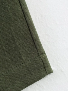 Detail of dark green ribbed knit cuff and high-quality stitching on bomber jacket