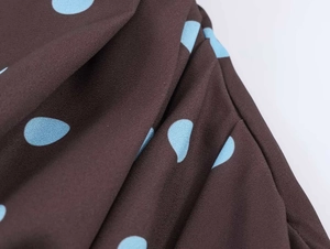 Detailed macro shot of coffee brown fabric with sky blue polka dots on a summer dress