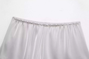 Λεπτομέρεια από ασημένιο σατέν σορτς με ελαστική μέση και απαλή υφή σαν μετάξι στο ύφασμα